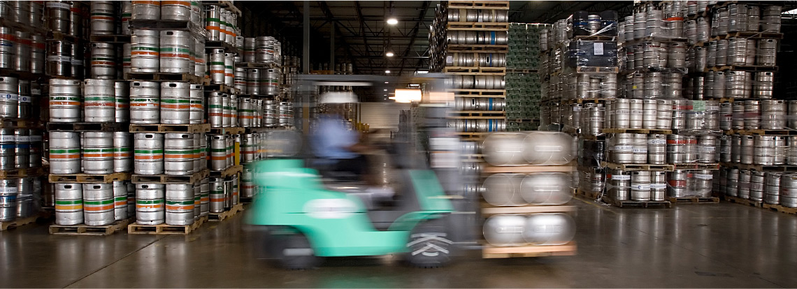 forklift moving kegs in a warehouse