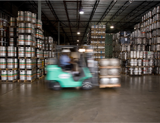 forklift moving kegs in a warehouse